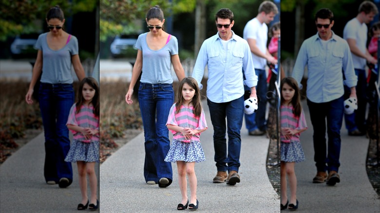 Suri Noelle walking in front of Tom Cruise and Katie Holmes