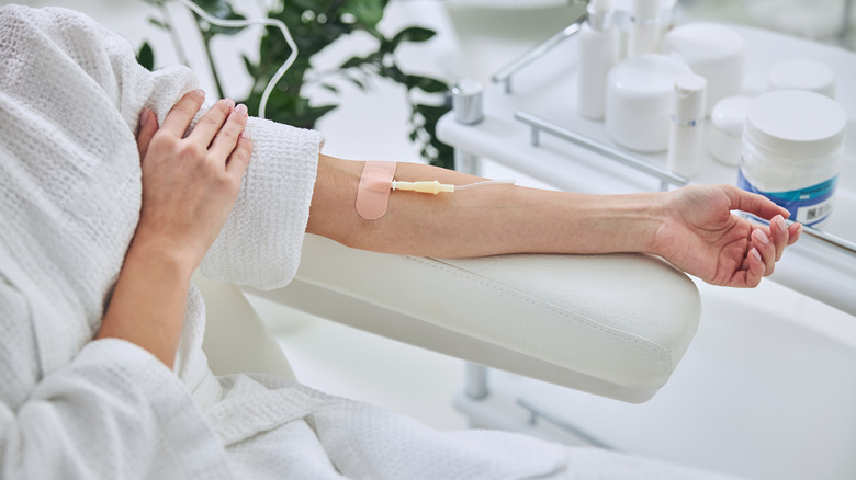 Woman in bathrobe getting IV therapy 