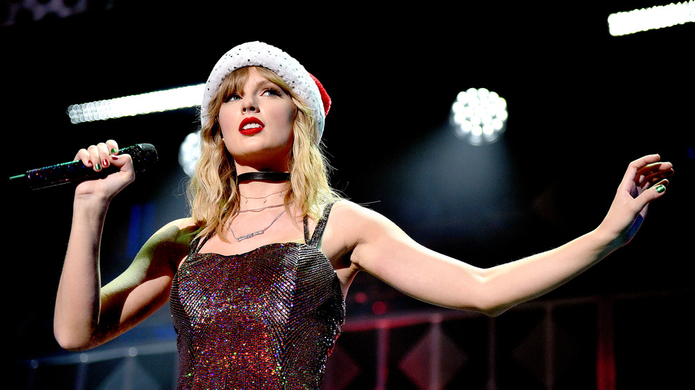 Taylor Swift performing in a Santa hat 