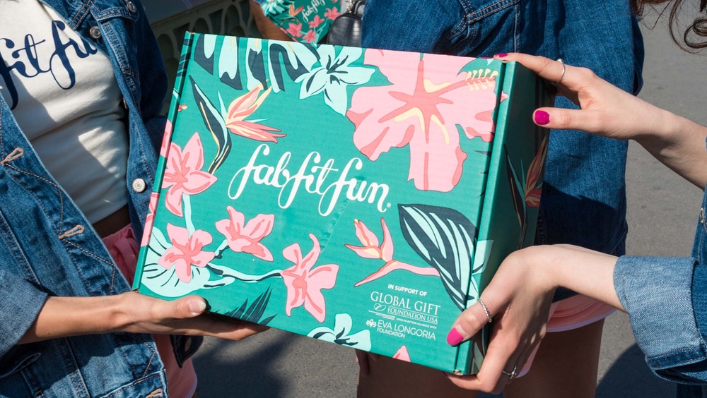 Multiple hands holding FabFitFun box 