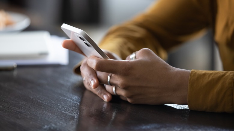 woman's hands texting on phone