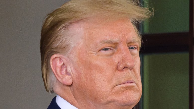 Donald Trump in a navy blue suit, red and blue striped tie