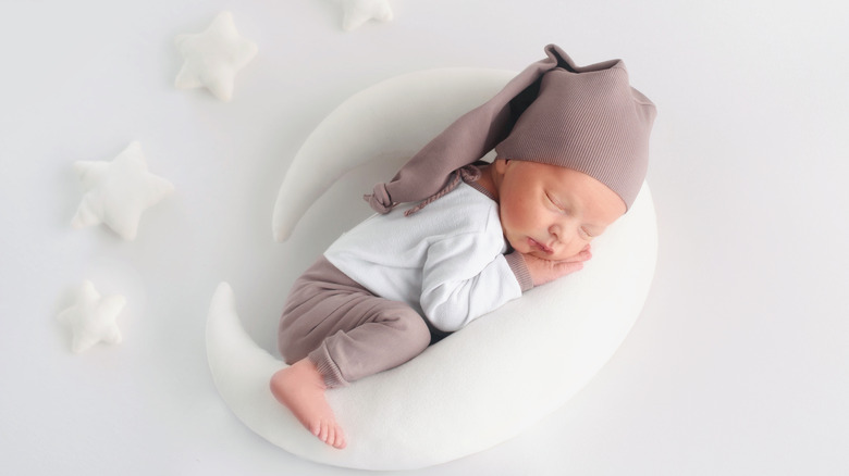 Baby sleeping on moon-shaped pillow