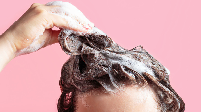 person washing hair with shampoo