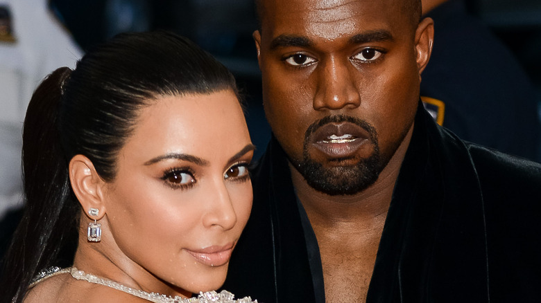 Kim Kardashian and Kanye West posing at event