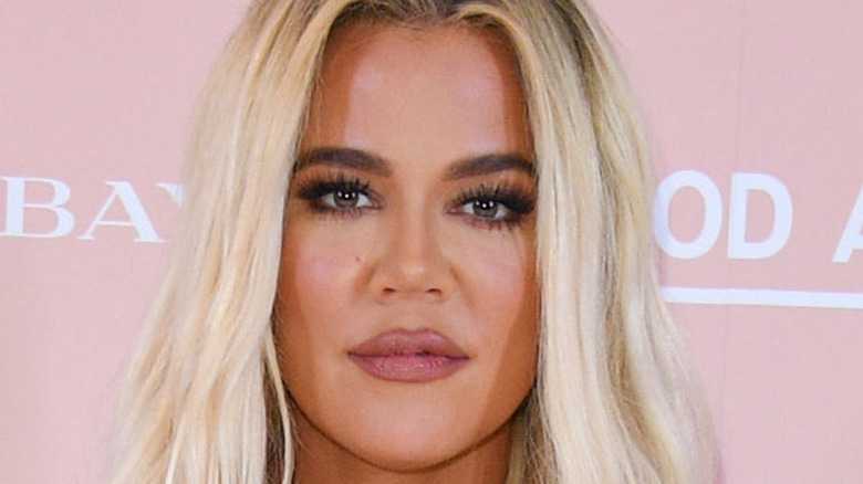 Khloé Kardashian poses for cameras at an event.