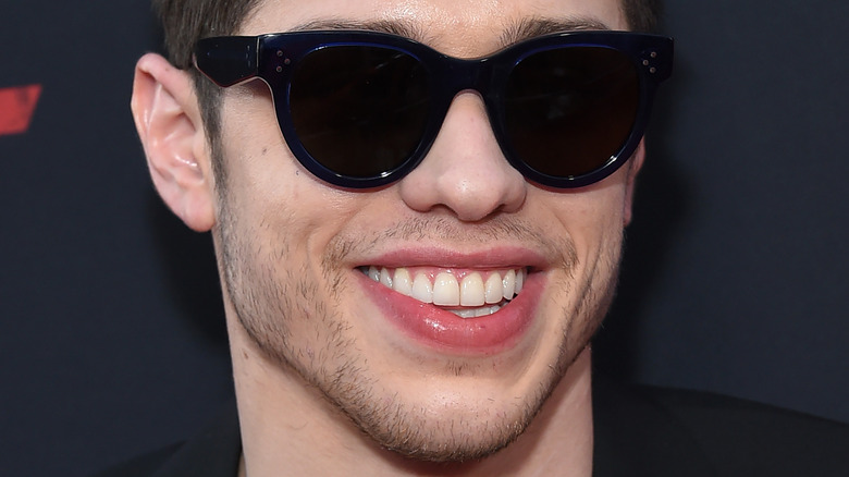 Pete Davidson smiles wearing sunglasses