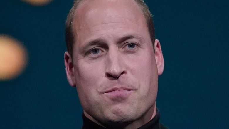 Prince William wearing a turtleneck and giving a speech