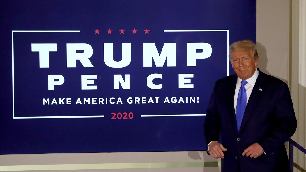 Trump next to a campaign sign