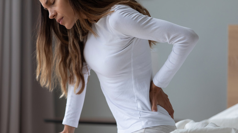 Woman with hand on her back