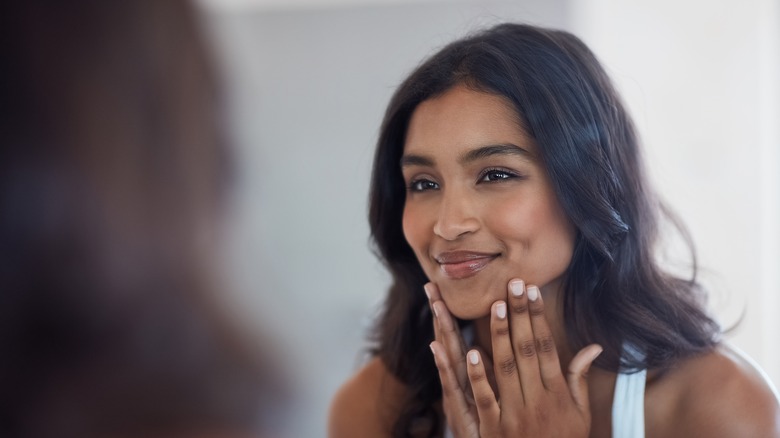 Woman looking at face in mirror