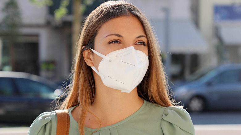 A woman wears a mask 