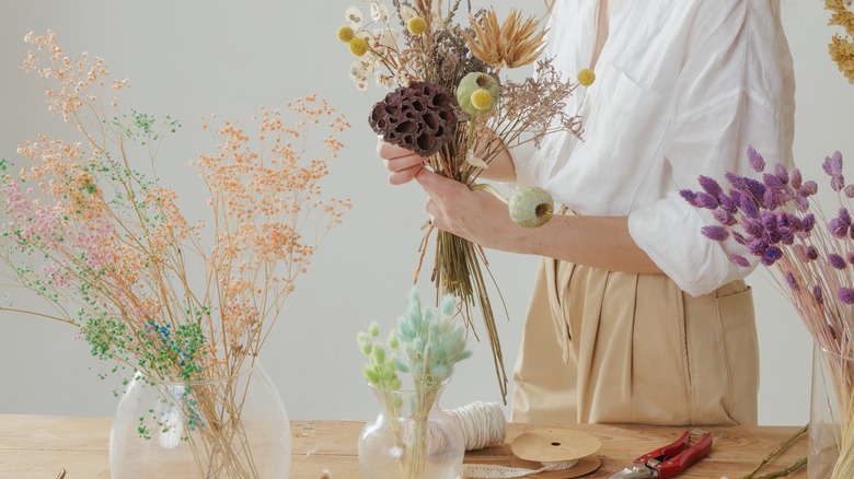 woman putting bouqets together in flower shop