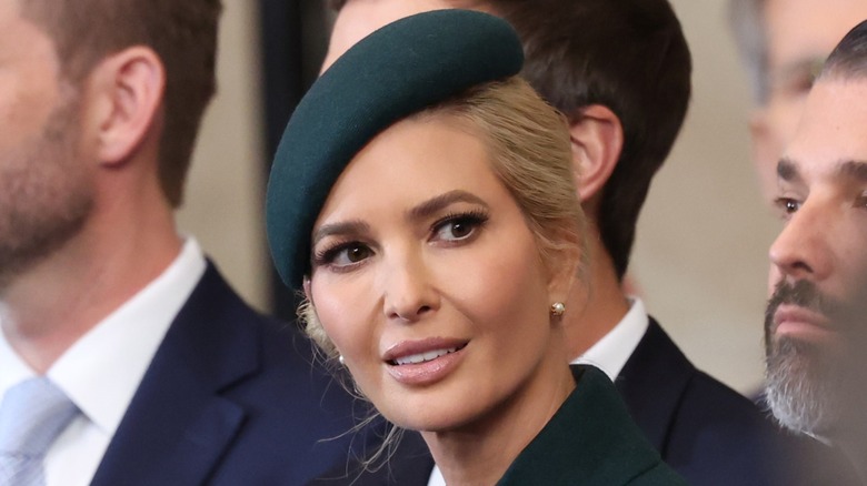 Ivanka Trump (center) wearing a forest green fascinator and looking to the side, with Eric Trump and Donald Trump Jr. cropped out the left and right