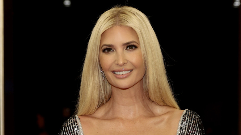 Ivanka Trump smiling in a silver dress with loose hair
