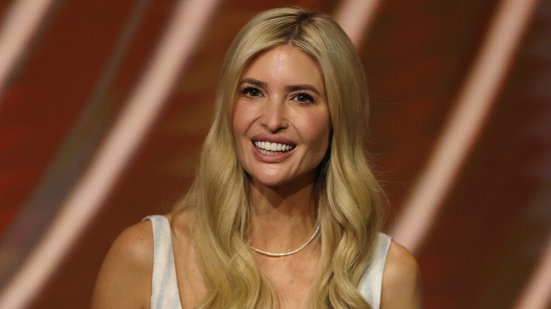 Ivanka Trump smiling in a white and blue dress.
