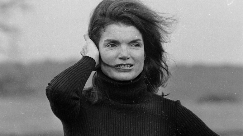 Jackie Kennedy pushing back hair in the wind
