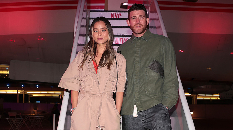 Jamie Chung and Bryan Greenberg standing on plane stairs