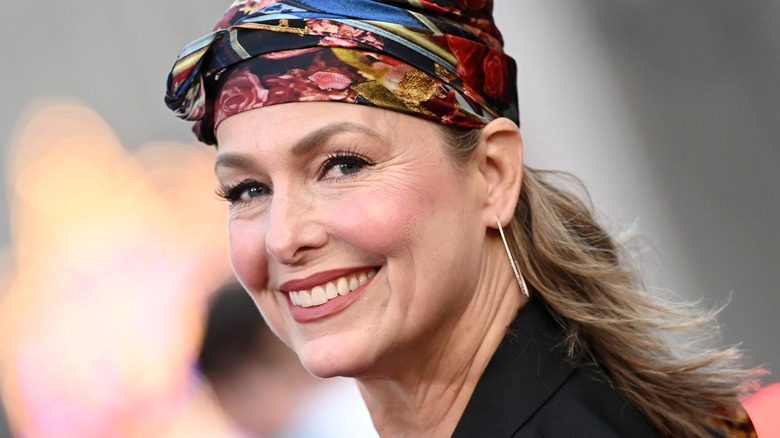 Melora Hardin wearing a bandana, earring, and a black jacket.