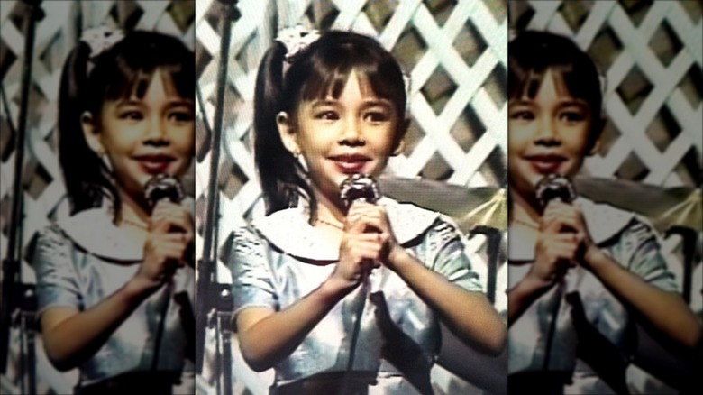 A young Janel Parrish singing in a home video