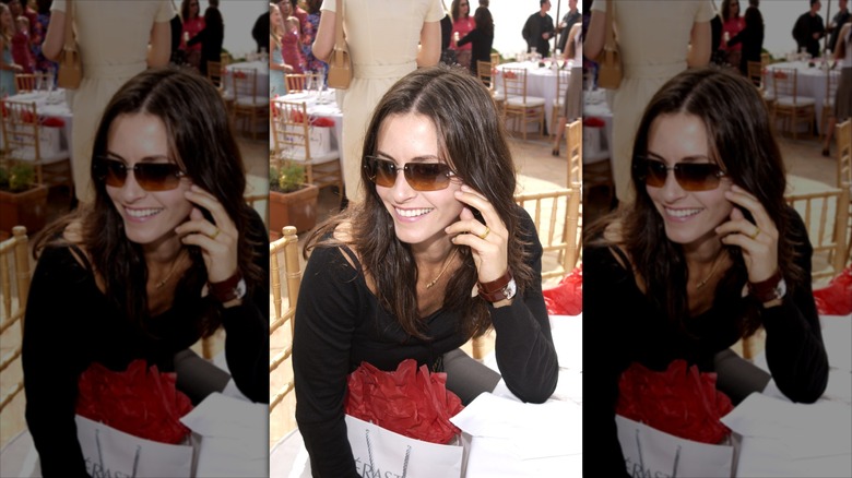 Courteney Cox in sunglasses, looking off camera to the left.
