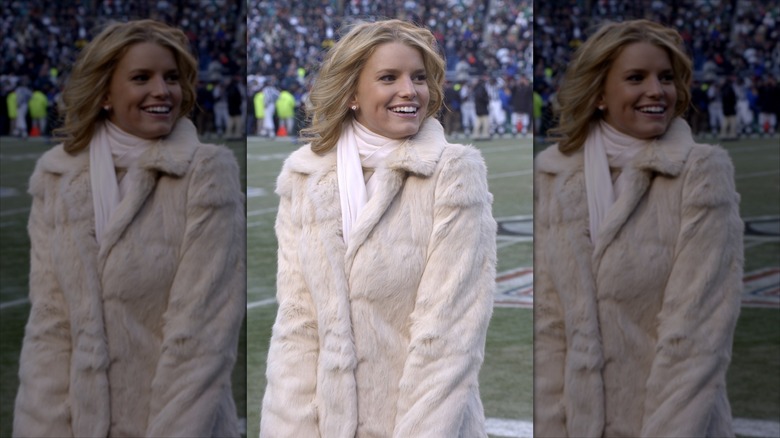Jessica Simpson in a pink fur coat on a football field.