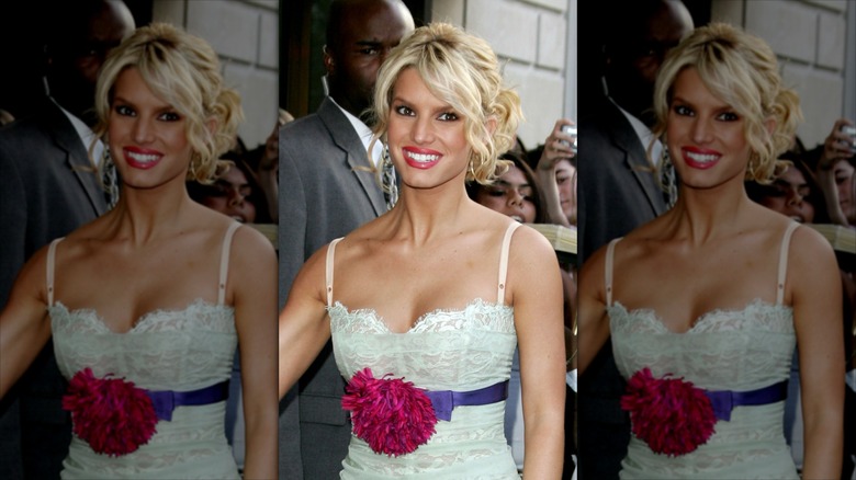Jessica Simpson in a white dress, surrounded by people.
