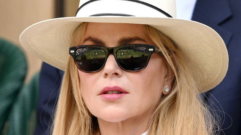 Nicole Kidman in a hat and sunglasses enthralled by a tennis match