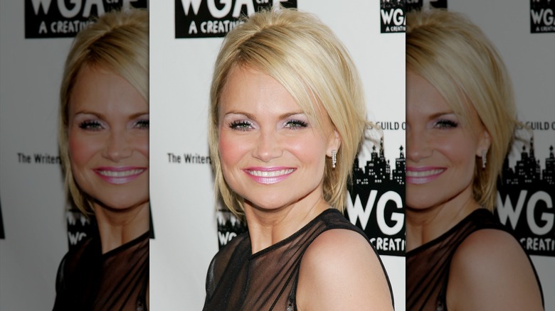 Kristin Chenoweth smiling with a blond bob in a black dress