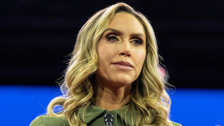Lara Trump speaking at a CPAC conference in a green shirt.