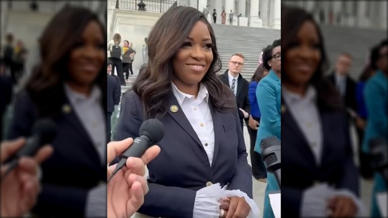 Jasmine Crockett, gesturing in a blazer outside.