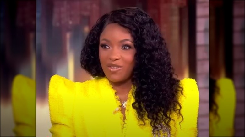 Jasmine Crockett in a neon yellow jacket at the table of The View show.
