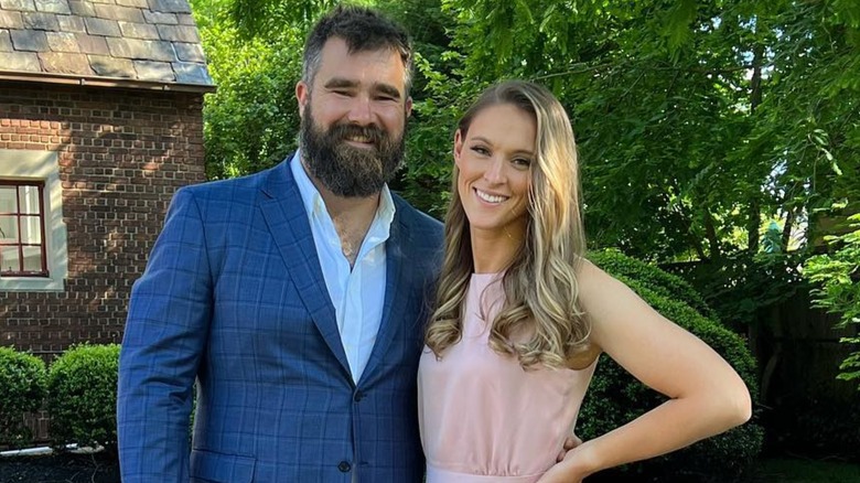 Jason Kelce in a blue suit with his arm around wife, Kylie Kelce.