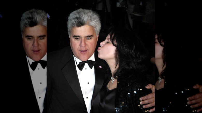 Mavis Leno poses with her lips pursed about to kiss Jay at a black tie event