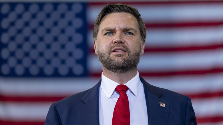 JD Vance stands in front of the American flag