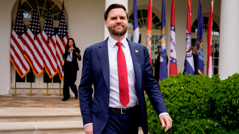 JD Vance walks and smiles for the camera