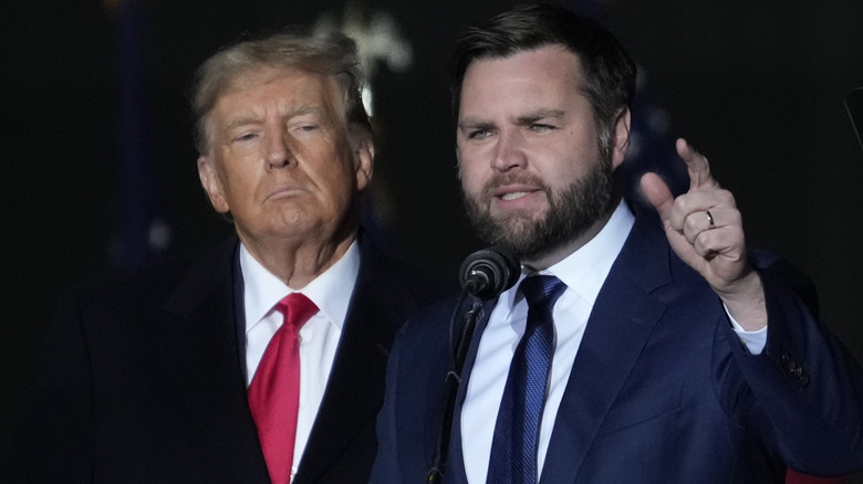 Donald Trump listens to JD Vance speak