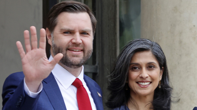 JD Vance waves while standing next to Usha Vance