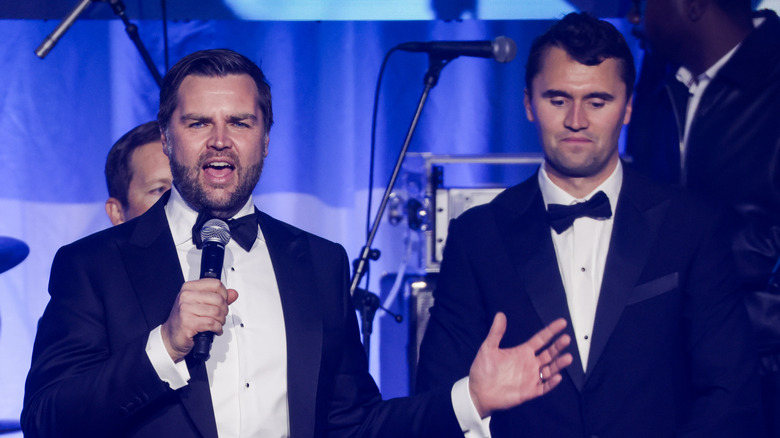 JD Vance stands next to Charlie Kirk onstage while both wearing tuxes