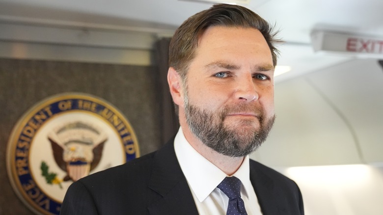 JD Vance looks at the camera onboard Air Force One in a suit