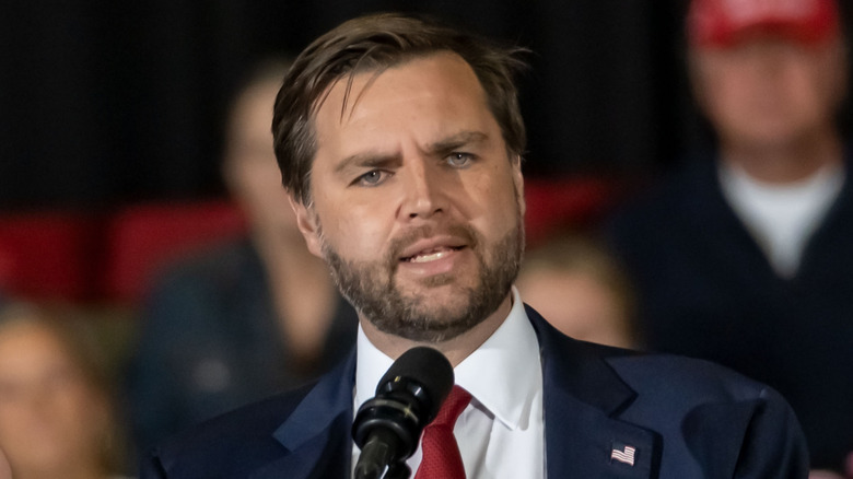 JD Vance talking into microphone holding one hand up