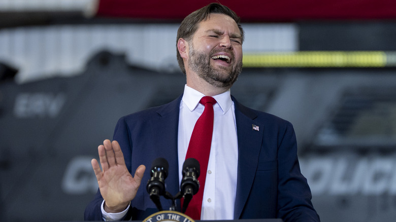 JD Vance laughing in front of the presidential podium