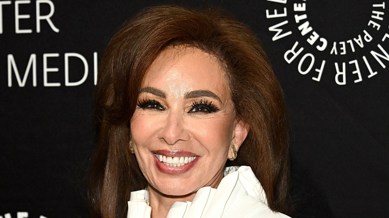 Judge Jeanine Pirro smiling in a white outfit.