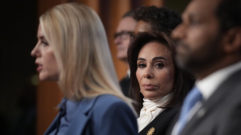 Jeanine Pirro glaring behind Pam Bondi