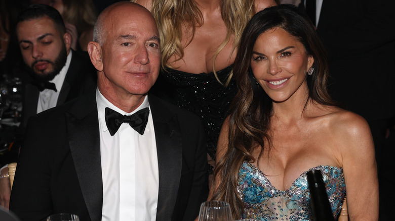 Jeff Bezos and Lauren Sanchez sitting next to each other in formal attire