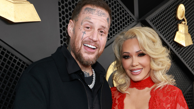 Jelly Roll and Bunnie Xo smiling at the cameras on the red carpet at the 2026 Grammy Awards