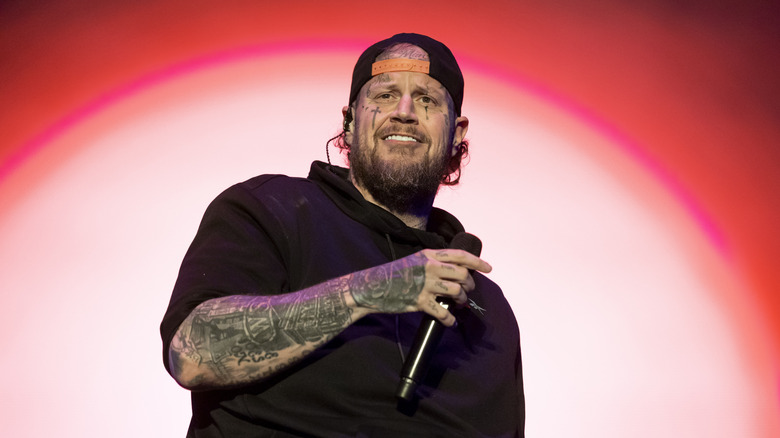 Jelly Roll holds a microphone onstage