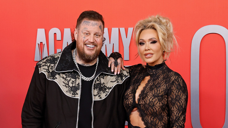 Jelly Roll smiling while posing alongside his wife Bunnie Xo