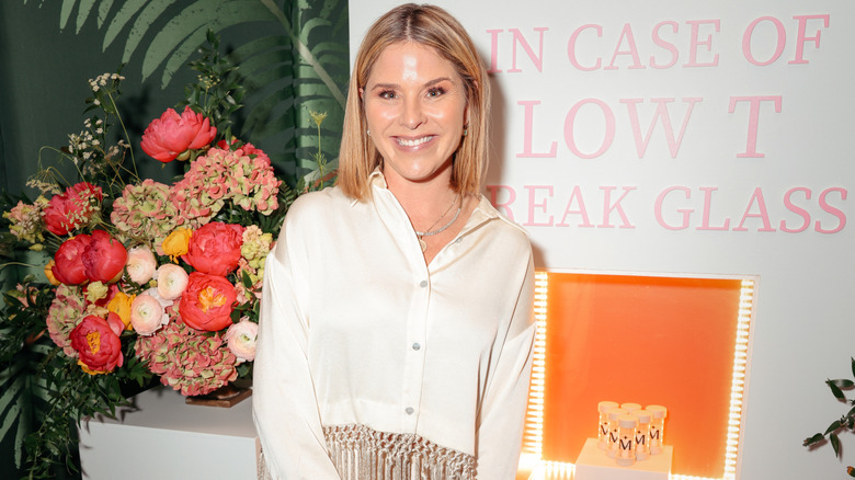 Jenna Bush Hager smiling while posing at an event in an off-white blouse