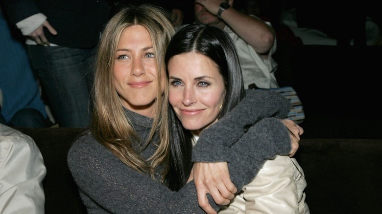 Jennifer Aniston hugging Courteney Cox at an event